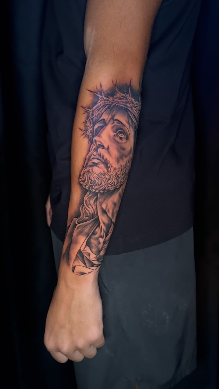 Detailed faith-inspired sleeve tattoo by Anthony